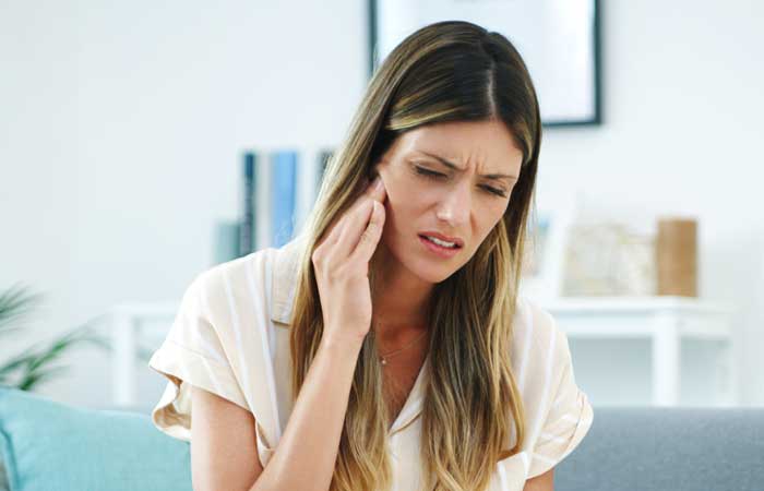 Woman holding face in pain